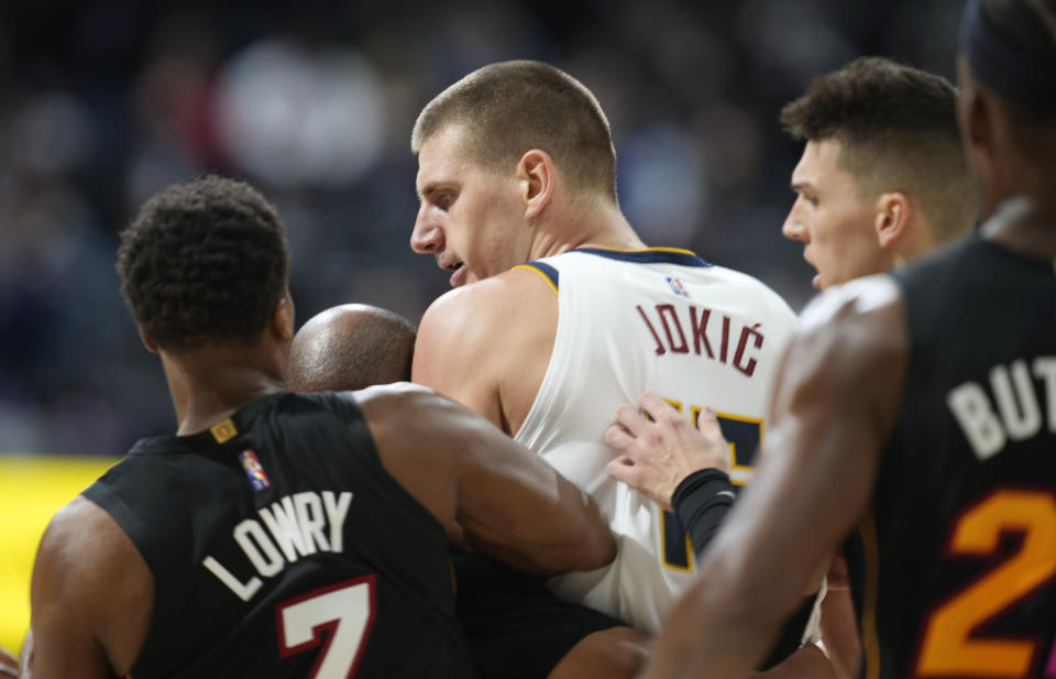 Denver Nuggets center Nikola Jokic, center, is restrained by Miami Heat guards Kyle Lowry, left, and Tyler Herro after knocking over Heat forward Markieff Morris during a scrum in the second half of an NBA basketball game Monday, Nov. 8, 2021, in Denver. Jokic was ejected, Morris assessed a personal foul for his part in the altercation. (AP Photo/David Zalubowski)