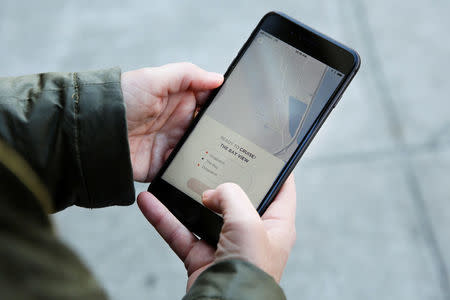 A journalist uses an app to summon a self-driving GM Bolt EV car during an event in San Francisco, California, U.S. November 28, 2017. REUTERS/Elijah Nouvelage