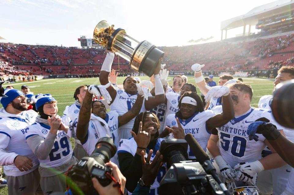 The Kentucky Wildcats, with Deone Walker holding up the Governor’s Cup trophy, celebrate their defeat of Louisville on Saturday at L&N Federal Credit Union.