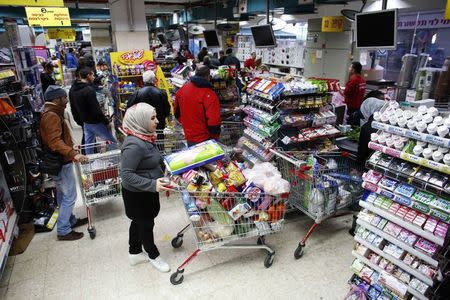 People stand at the checkout line in a supermarket in Jerusalem January 6, 2015. REUTERS/Ronen Zvulun