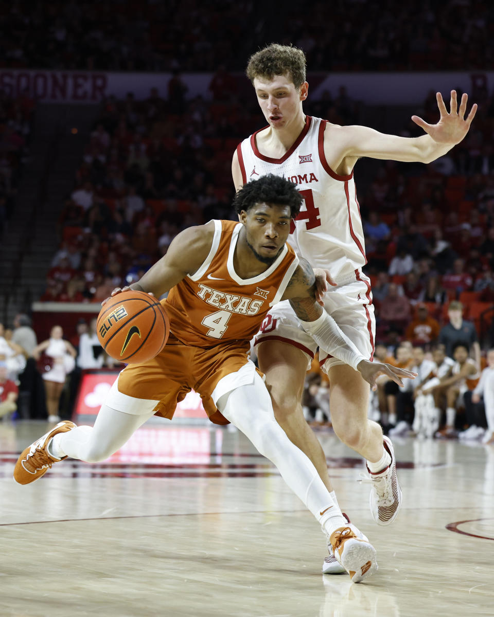 Texas guard Tyrese Hunter (4) goes against Oklahoma forward Jacob Groves during the first half of an NCAA college basketball game Saturday, Dec. 31, 2022, in Norman, Okla. (AP Photo/Garett Fisbeck)