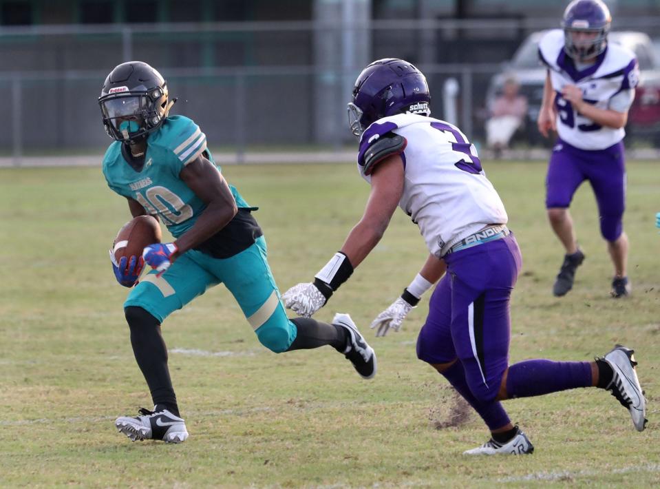 Pine Ridge High's Chris Boddie #10 turns the corner as a Space Coast player gives chase, Friday September 8, 2023.