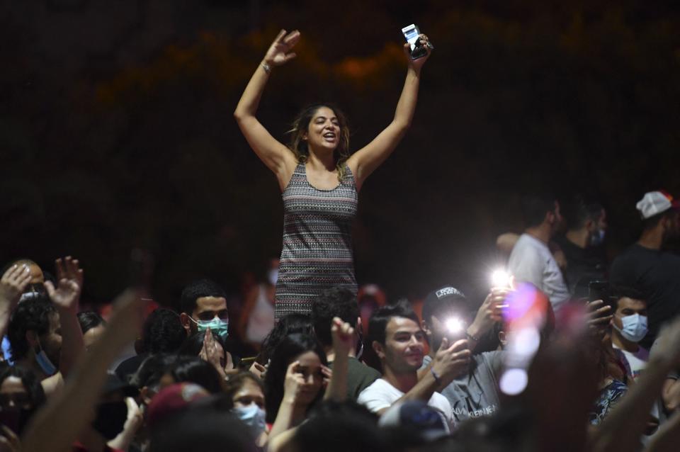 People celebrate in the street after Tunisian President Kais Saied announced the dissolution of parliament and Prime Minister Hichem Mechichi's government in Tunis on July 25 (AFP via Getty Images)