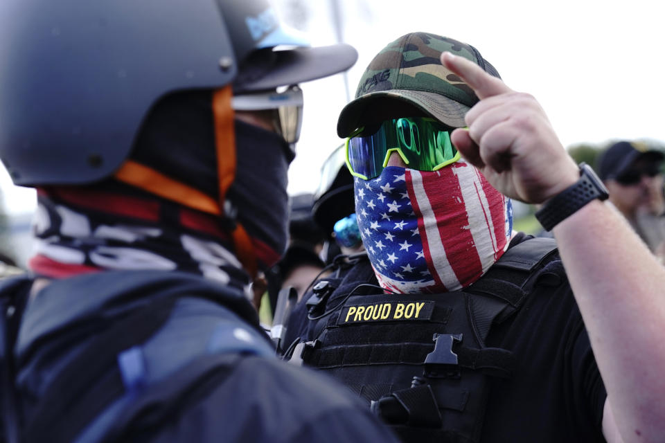 A right-wing demonstrator, right, gestures toward a counter protester as members of the Proud Boys and other right-wing demonstrators rally on Saturday, Sept. 26, 2020, in Portland, Ore.About 200 people gathered in Portland, for a right-wing rally, dozens of them wearing militarized body armor. It was far fewer than the thousands expected to appear. (AP Photo/John Locher)