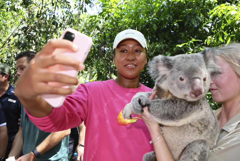 Naomi Osaka of Japan takes a selfie with Milton, a koala bear, during a visit to the Lone Pine sanctuary ahead of the Brisbane International tennis tournament in Brisbane, Australia, Friday, Dec. 29, 2023. (AP Photo/Tertius Pickard)