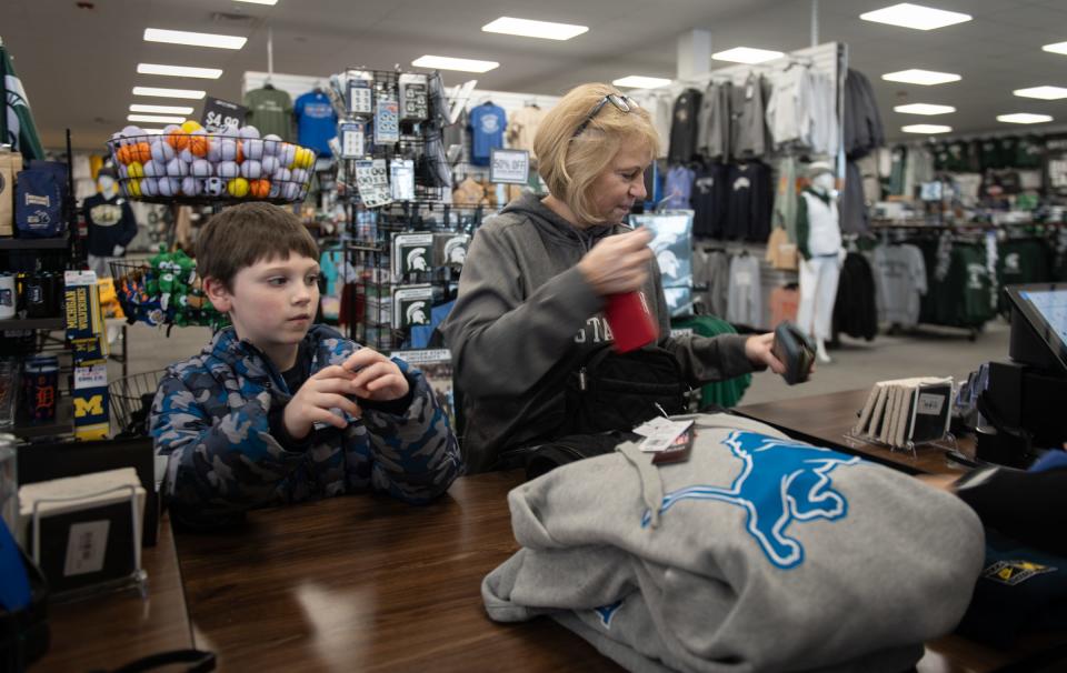 Detroit Lions football fans Diane Smith of Lansing and grandson Easton McGillis, 7, shop Monday, Jan. 22, 2024, at Rally House East Lansing. Smith bought two Lions sweatshirts for herself and her husband.