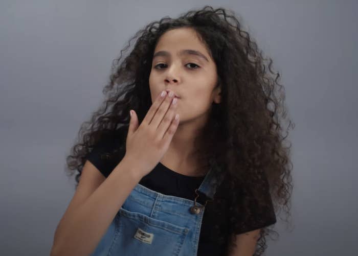 Monroe blows a kiss while wearing denim overalls and a black T-shirt