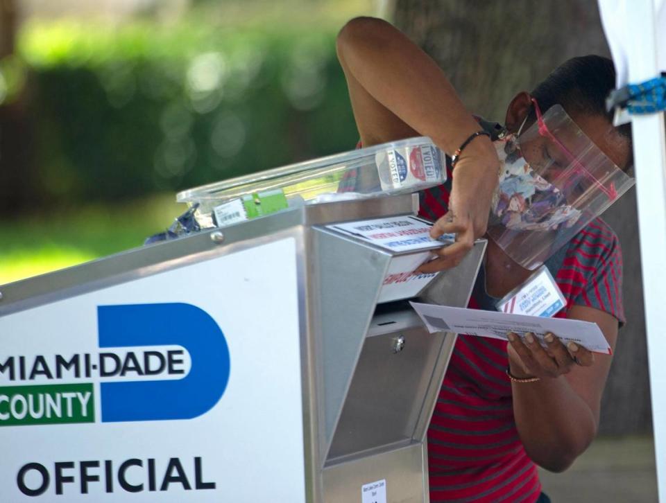 A poll worker deposits a ballot after collecting from a citizen during the early voting for primary election at Miami Lakes Community Center located at 15151 Montrose Rd. in Hialeah on Thursday, August 13, 2020.