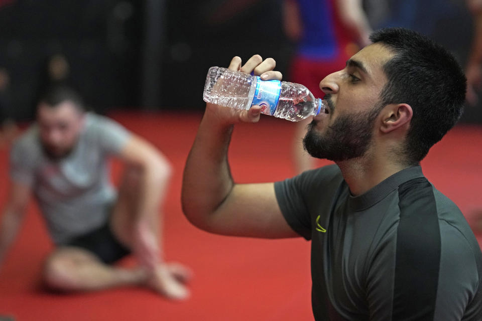 A student drinks water during a break at a mixed martial arts practice session at Diesel Gym in the Docklands area of East London, Monday, March 25, 2024. The special sessions run by the nonprofit SCK Fitness are held at 10 p.m. during the Muslim holy month of Ramadan to accommodate dawn-to-dusk fasting. (AP Photo/Kin Cheung)