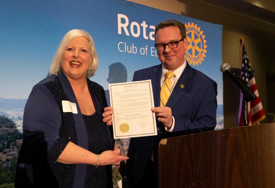 Eugene Rotary club president Liz Ness, left, and Eugene City Councilor Matt Keating, Ward 2 showoff a proclamation by Mayor Lucy Vinis declaring March 15 Rotary Club of Eugene Day as the club celebrates 100 years in Eugene.