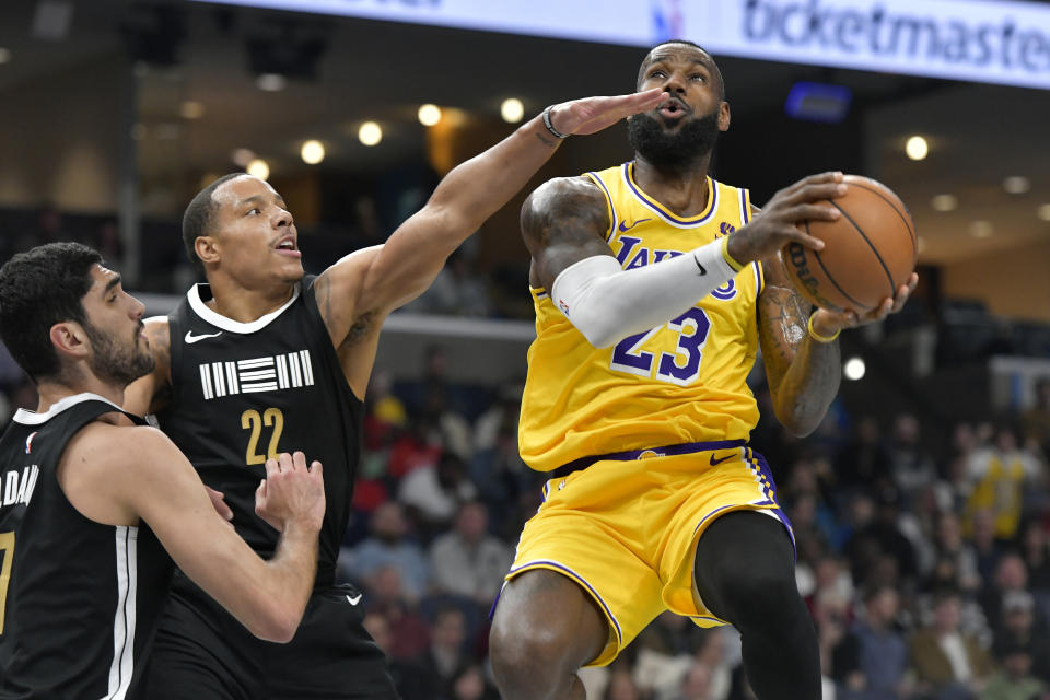 Los Angeles Lakers forward LeBron James (23) shoots against Memphis Grizzlies guard Desmond Bane (22) and forward Santi Aldama (7) in the first half of an NBA basketball game Wednesday, March 27, 2024, in Memphis, Tenn. (AP Photo/Brandon Dill)