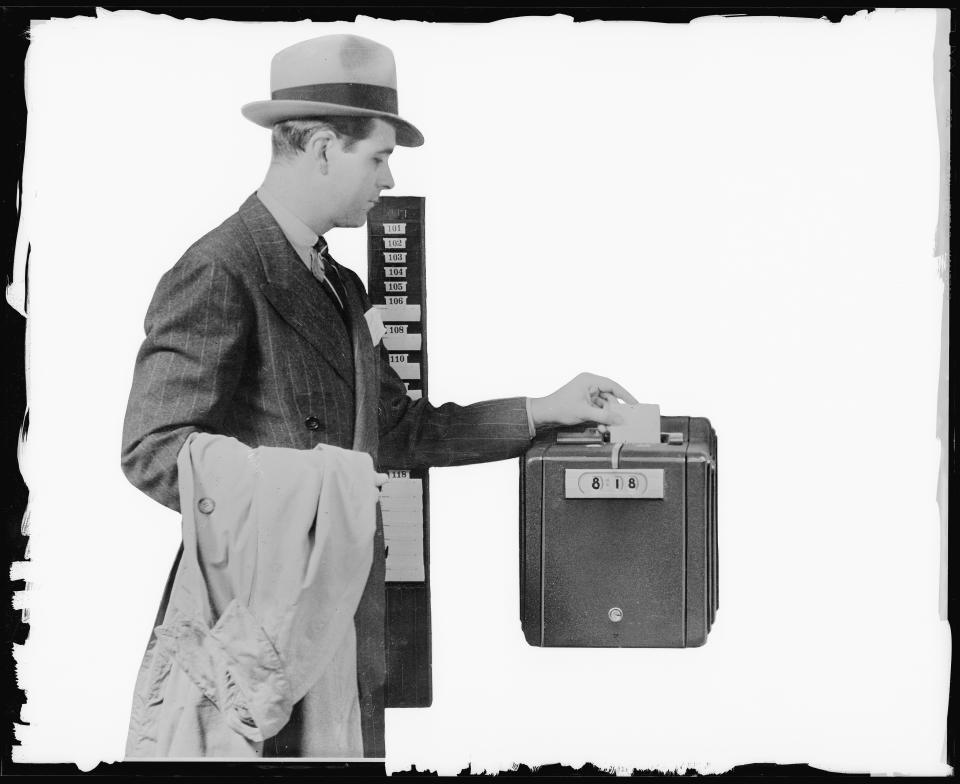 (Original Caption) Punching a time clock, ca. 1942. Photograph.