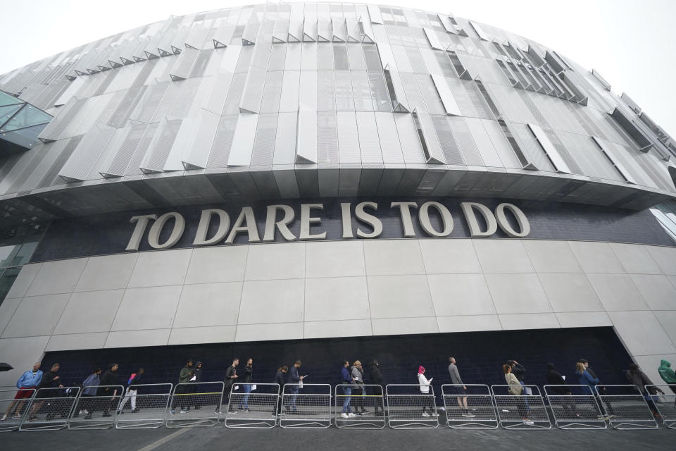 People queue at an NHS Vaccination Clinic at Tottenham Hotspur's stadium in north London, Sunday, June 20, 2021. The NHS is braced for high demand as anyone in England over the age of 18 can now book a Covid-19 vaccination jab. (Yui Mok/PA via AP)