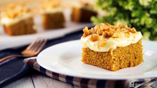 Coffee Hot Milk Cake with Cream Cheese and Walnuts Dish close up with slices of cake in the background