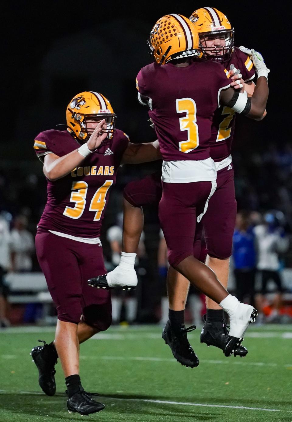 Bloomington North’s Zeke Trueblood (34), Stephon Opoku (3) and Lucas Rice (42) celebrate after a play during the football game against Columbus North at Bloomington North on Friday, Oct. 6, 2023.
