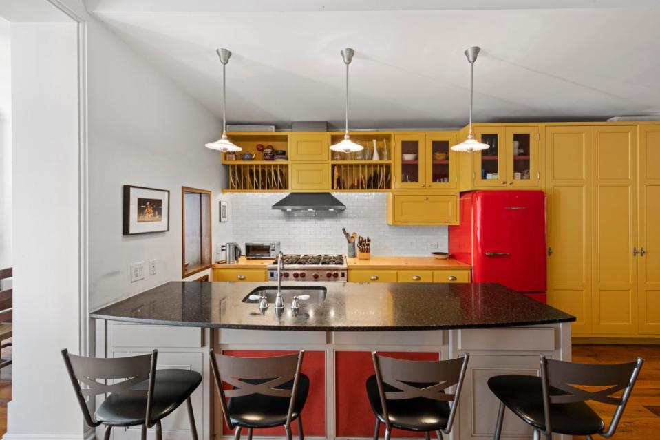 The open kitchen with its retro red fridge and mustard yellow cabinetry hasn’t changed since Hawke’s time in the townhouse. Richard Caplan