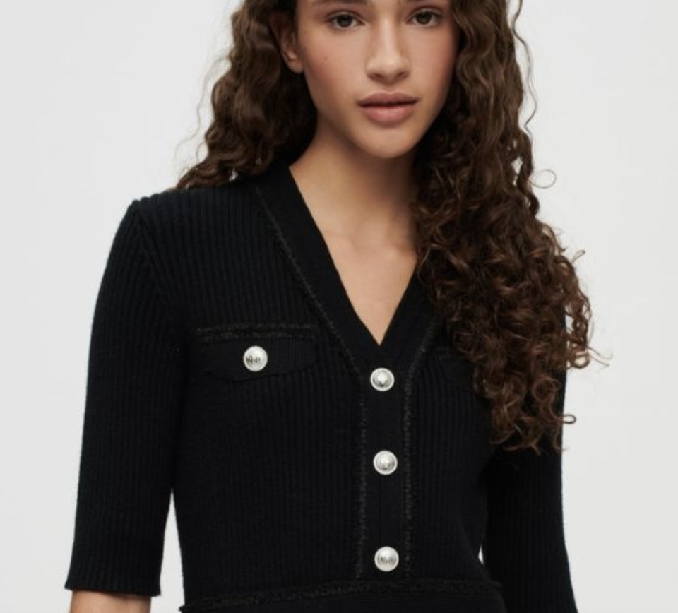 A photo of a model in Maje Black Ribbed Viscose Knit Dress.