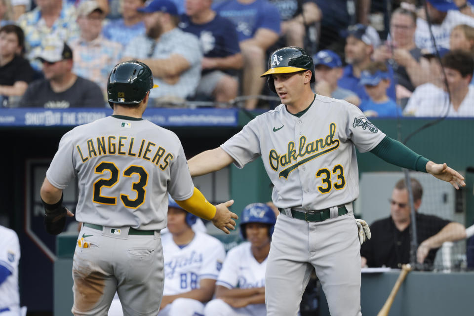 Oakland Athletics' Shea Langeliers (23) and JJ Bleday (33) celebrate after they scored off a Esteury Ruiz single during the second inning of a baseball game against the Kansas City Royals in Kansas City, Mo., Saturday, May 6, 2023. (AP Photo/Colin E. Braley)