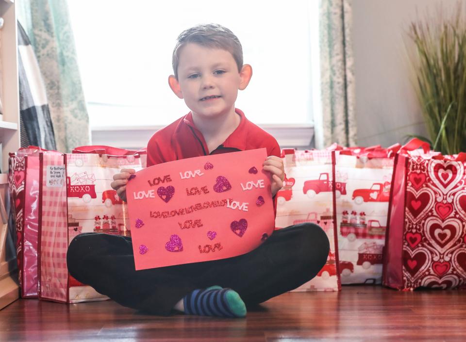 Holding a Valentine's card he crafted, Beckham Goodale is surrounded at his Charlestown, Ind. by bags filled with candy and cards that he will give out to other kids battling cancer and his own doctors and nurses at Norton Children's Cancer Institute. The 7-year-old has leukemia and earned the nickname Candy Man after always giving candy to his doctors and nurses. He loves to see people smile, regardless how he may be feeling that day. Feb. 9, 2022