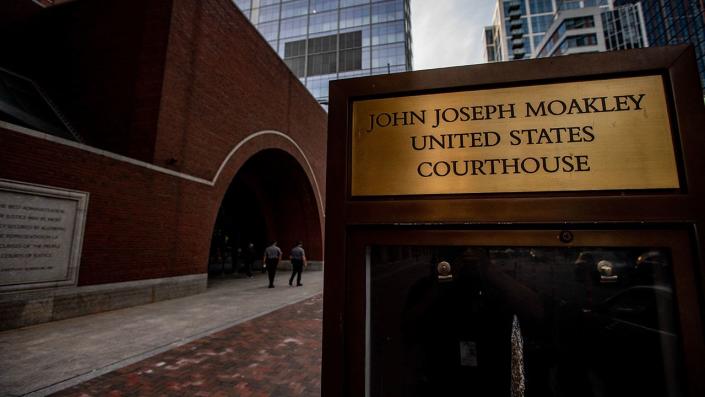 Security guards walk the by the entrance to the John Joseph Moakley United States Courthouse, in Boston on April 14, 2023. Jack Teixeira, 21, an employee of the U.S. Air Force National Guard, was due to appear at the federal court on Friday, authorities said, after he was arrested o suspicion of leaking a trove of sensitive U.S. government secrets.