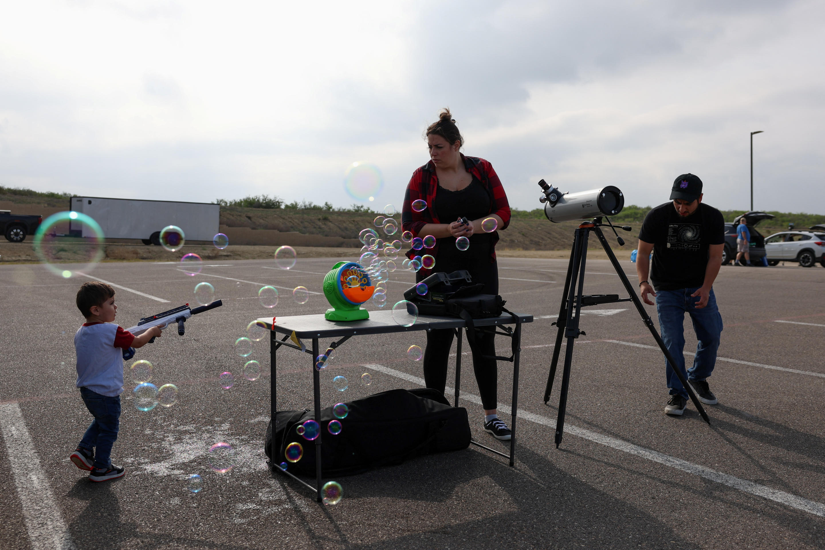 People stand next to bubbles as they assemble to view a total solar eclipse, where the moon will blot out the sun, in Eagle Pass, Texas.