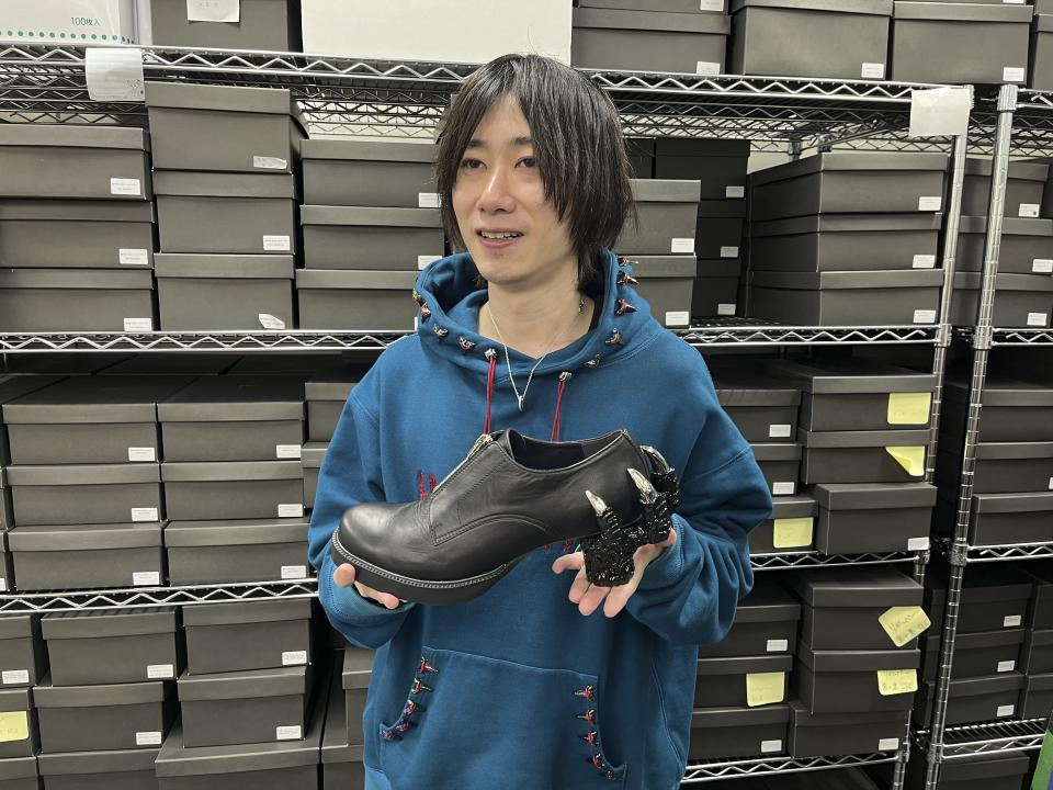Ryosuke Matsui, el diseñador japonés de los zapatos de Godzilla que usó el equipo de la película galardonada con el premio a los mejores efectos visuales "Godzilla Minus One" en la ceremonia de los Oscar, sostiene uno de sus diseños durante una entrevista con The Associated Press en las oficinas de su empresa ea las afueras de Tokio el viernes 22 de marzo de 2024. (Foto AP/Yuri Kageyama)