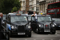 London taxi drivers park their cabs on the junction of Whitehall and Parliament Square, as they take part in a protest to jam traffic in reaction to not being allowed to use the Olympic driving lanes in London, Tuesday, July 17, 2012. (AP Photo/Matt Dunham)