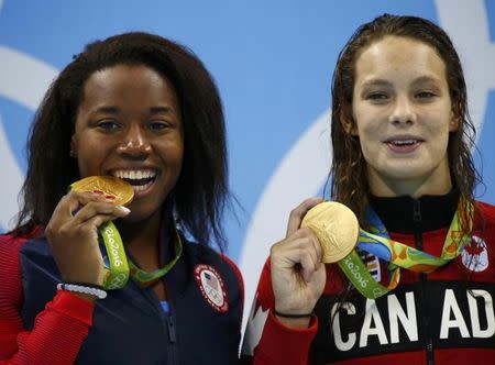 Simone Manuel (USA) and Penelope Oleksiak pose with their medals on the podium. REUTERS/David Gray