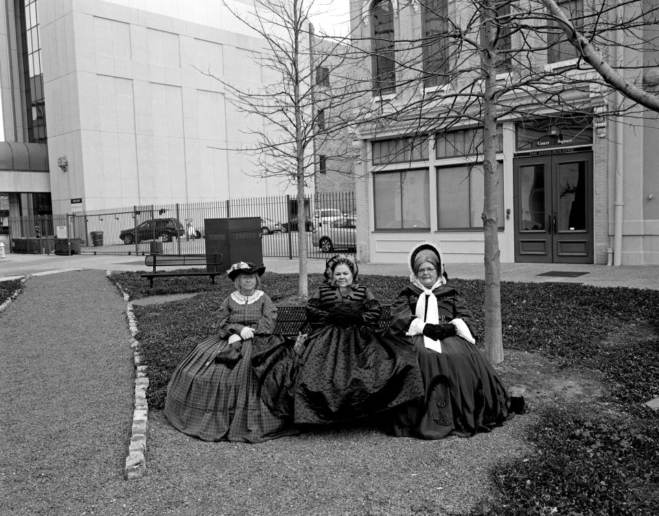 <p>“American Memory”: Montgomery, Ala., 2011. To celebrate the 150th anniversary of the inauguration of President Jefferson Davis, Civil War reenactors hold a rally in downtown Montgomery, the first capitol of the Confederacy. Perhaps by coincidence, these women, waiting for the rally to begin, are sitting on a park bench where Rosa Parks boarded the city bus she was arrested on in 1955, which helped launch the civil rights movement. (© Andrew Lichtenstein from “War Is Only Half the Story,” the Aftermath Project & Dewi Lewis Publishing) </p>