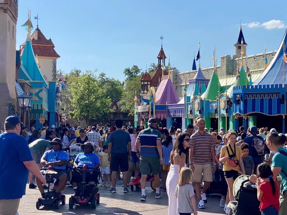 crowds walking through the fantasyland attractions at magic kingdom during spring break