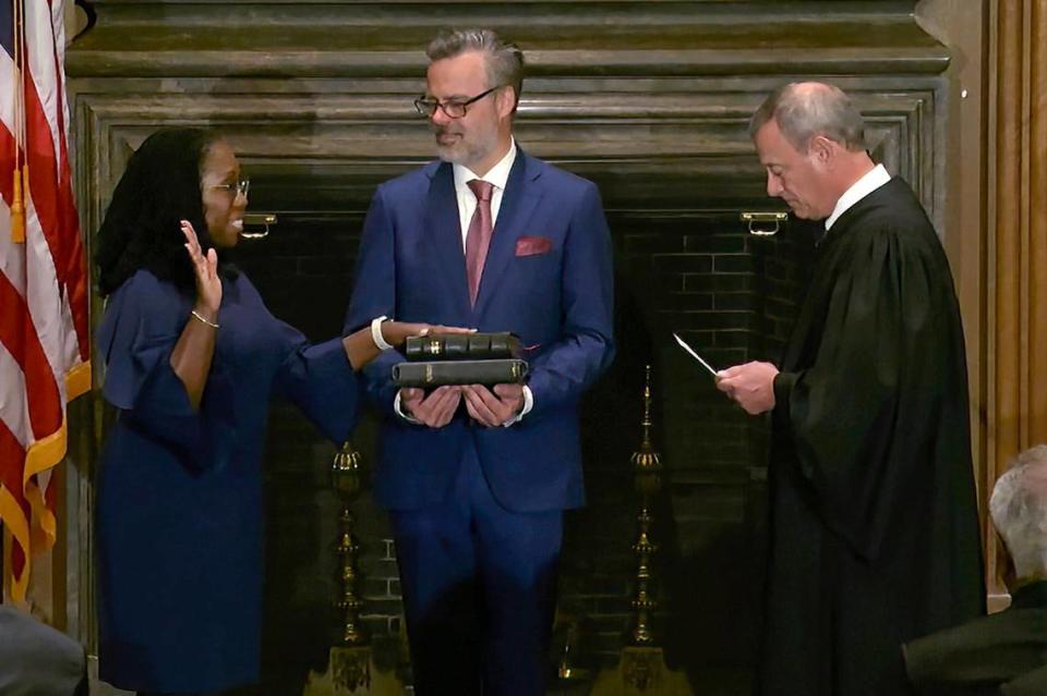 In this image from video provided by the Supreme Court, Chief Justice of the United States John Roberts administers the Constitutional Oath to Ketanji Brown Jackson as her husband Patrick Jackson holds the Bible at the Supreme Court in Washington, Thursday, June 30, 2022.