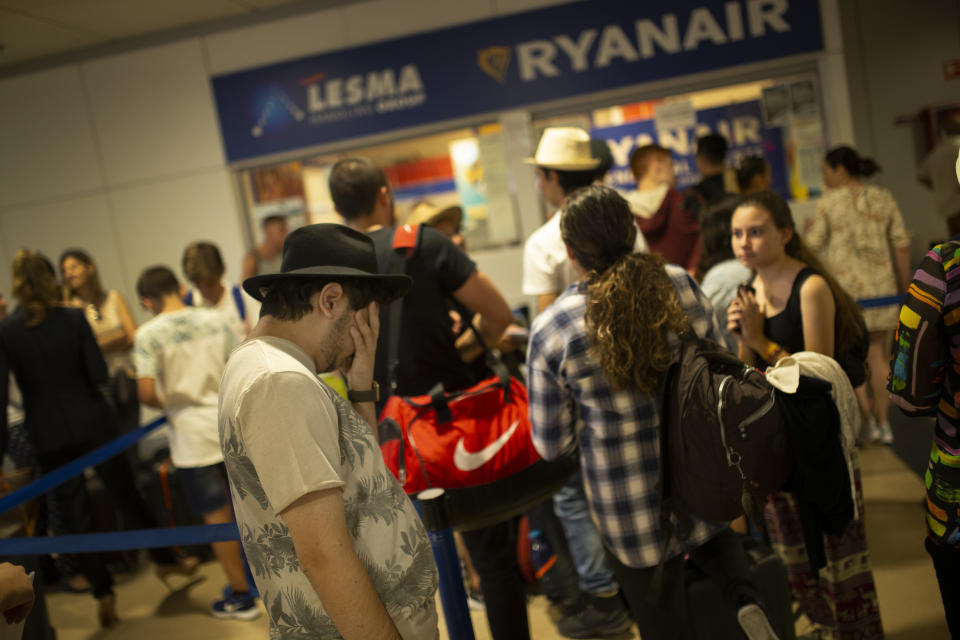 People queue at the Ryanair airline customer service desk during the first of two days cabin crew strike at Adolfo Suarez-Barajas international airport in Madrid, Wednesday, July 25, 2018. Cabin crew workers for low-cost airline Ryanair went on strike in four European countries over working conditions, forcing thousands of passengers to make last-minute travel adjustments at the peak of the summer holiday season. (AP Photo/Francisco Seco)