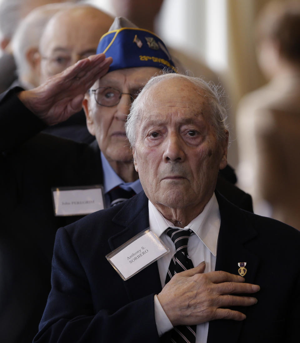 World War II veterans Anthony Sorbero of Amsterdam, N.Y., front, and John Peregrim of Devon, Conn., stand for the national anthems of France and the United States before being presented with the insignia of the French Legion of Honor during a ceremony at the U.S. Military Academy, on Friday, May 9, 2014, in West Point, N.Y. Thirty-four U.S. veterans were honored 70 years after the D-Day landings. (AP Photo/Mike Groll)