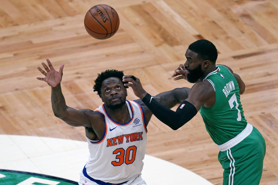 New York Knicks forward Julius Randle (30) looks up to catch a pass as Boston Celtics guard Jaylen Brown (7) defends during the first half of an NBA basketball game Wednesday, April 7, 2021, in Boston. (AP Photo/Charles Krupa)