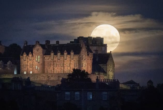 The full moon rises behind Edinburgh Castle. Otherwise known as Thunder Moon, the July full moon is synonymous with summer storms (Photo: Jane Barlow - PA Images via Getty Images)