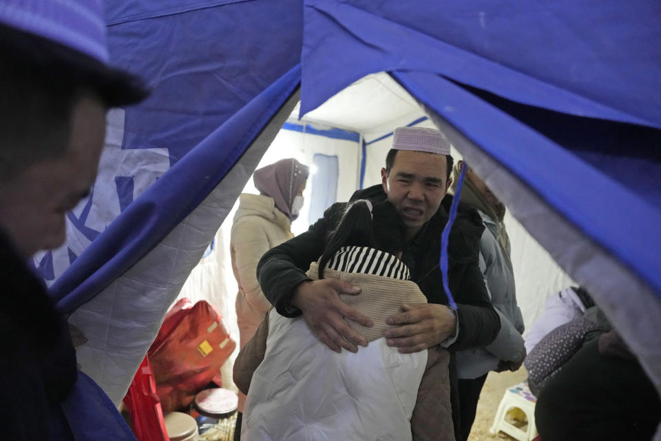 Ma Lianqiang hugs his daughter as they grieve the death of his wife and her mother who were killed by the earthquake in Yangwa village near Dahejia town in northwestern China's Gansu province, Wednesday, Dec. 20, 2023. A strong overnight earthquake rattled a mountainous region of northwestern China, authorities said Tuesday, destroying homes, leaving residents out in a below-freezing winter night and killing many in the nation's deadliest quake in nine years. (AP Photo/Ng Han Guan)