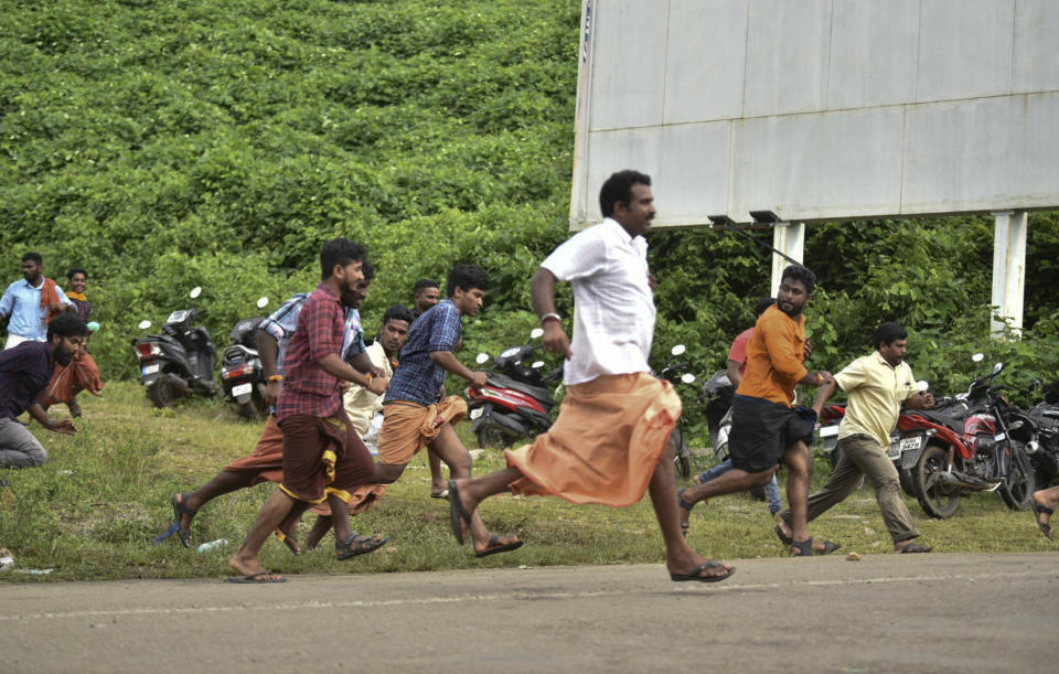 FILE - In this Wednesday, Oct. 17, 2018 file photo, protestors run after being chased by police for trying to stop women of menstruating age from going to Sabarimala temple at Nilackal, a base camp on way to the mountain shrine in Kerala, India. India's ruling party and the main opposition are both supporting a protest to keep females of menstruating age from entering one of the world's largest Hindu pilgrimage sites, in what some political observers say is a bid to shore up votes ahead of next year's general election. Throngs of male devotees defied the Sept. 28 ruling, which found the temple’s prohibition of women of menstruating age unconstitutional, demanding that females show proof of age before allowing them to travel onward. (AP Photo)
