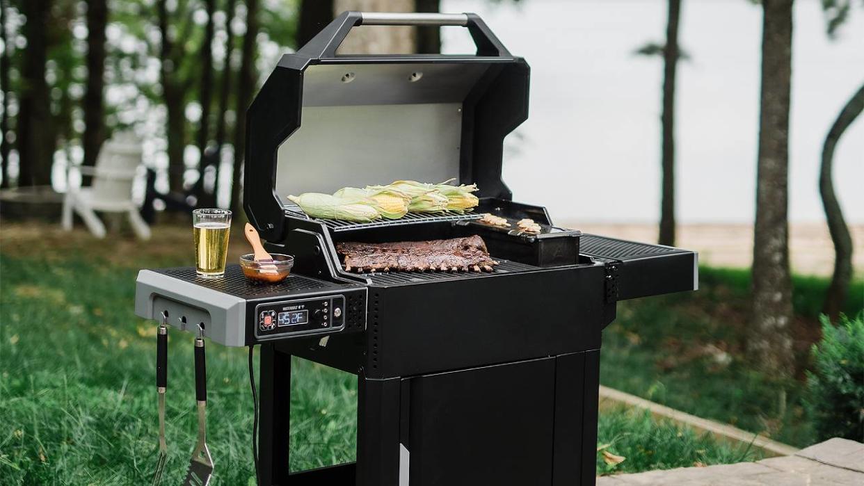  A lifestyle image of the Masterbuilt AutoIgnite Series 545 with food on the grill. 