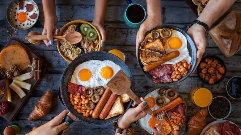 Breakfast table with fry up, fruit and cereal, and pastries