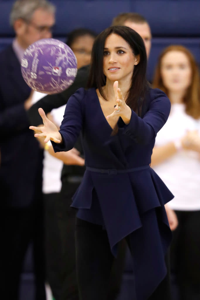 The Duchess of Sussex didn’t even take her heels off to play netball with the apprentices [Photo: Getty]