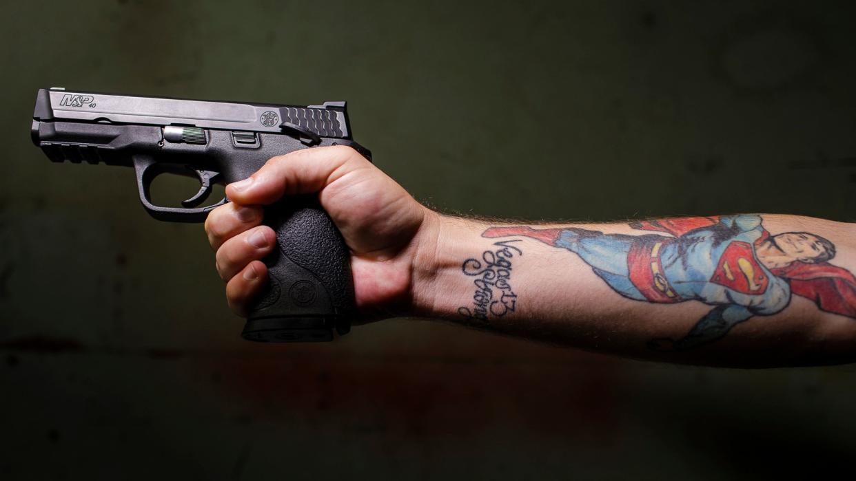 Shane Hooper with his Smith &amp; Wesson M&amp;P 40. He also owns a pump-action shotgun he doesn't want anymore but hasn't been able to get rid of. (Photo: Leah Nash for HuffPost)