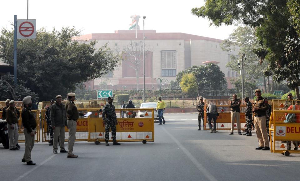 Ινδικό προσωπικό ασφαλείας και αστυνομικοί του Δελχί ελέγχουν ανθρώπους και οχήματα στο δρόμο προς το κτίριο του Κοινοβουλίου στο Νέο Δελχί, Ινδία, 13 Δεκεμβρίου 2023 (EPA)