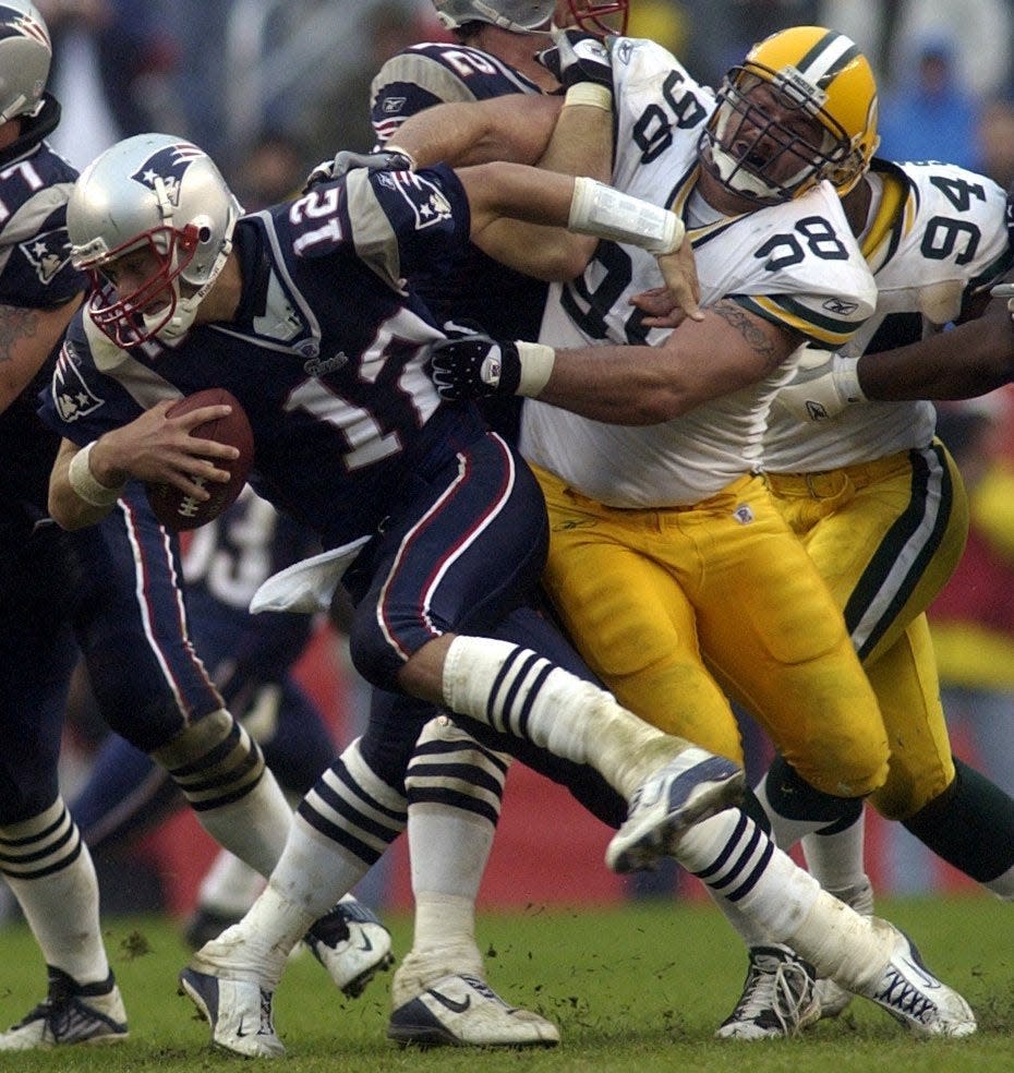 New England Patriots quarterback Tom Brady is unable to shake the grasp of Green Bay Packers Billy Lyon during the fourth quarter of their 2002 game at Gillette Stadium.