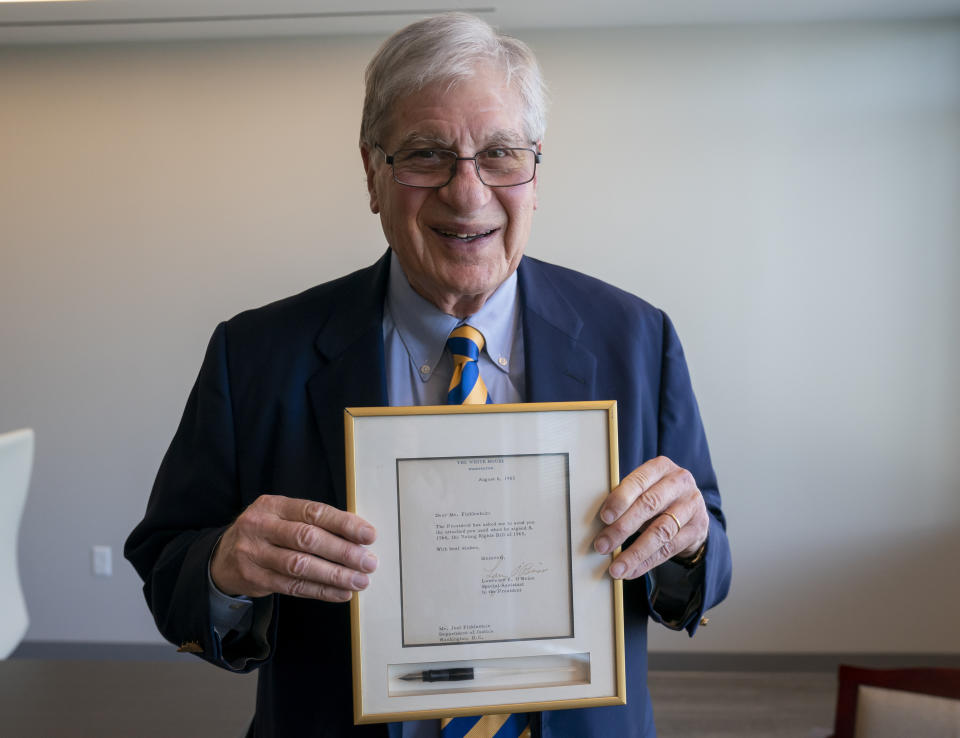 Attorney Joel Finkelstein, who was present at the signing of the Voting Rights Act of 1965, displays one of the pens used by President Lyndon Johnson at that historic event, during an interview with The Associated Press at his office in Rockville, Md., April 13, 2023. Finkelstein began his career as a young lawyer in the Civil Rights Division of the Department of Justice in 1964. (AP Photo/J. Scott Applewhite)