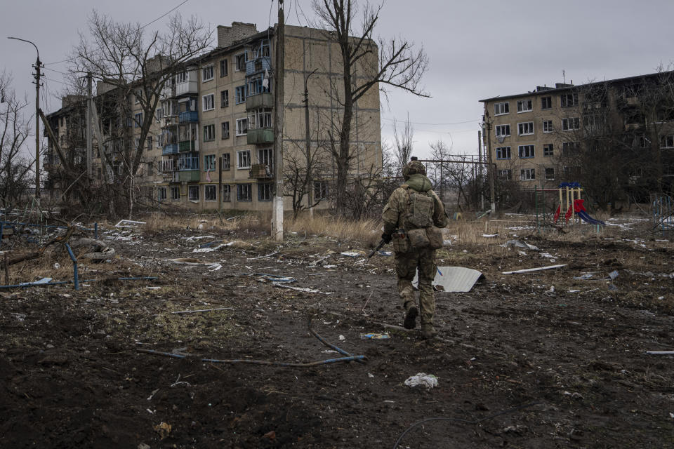 A Ukrainian marine serviceman runs to take a position through the residential blocks in the frontline city of Vuhledar, Ukraine, Saturday, Feb. 25, 2023. (AP Photo/Evgeniy Maloletka)