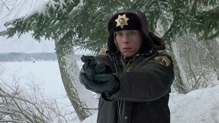 Frances McDormand as Marge Gunderson aiming a gun at someone off-camera in Fargo.