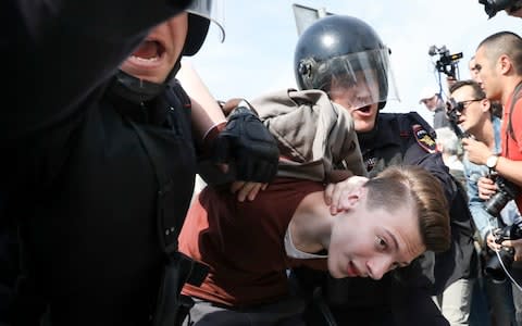 Russian police detain a protester at a demonstration against President Vladimir Putin in Pushkin Square in Moscow - Credit: AP