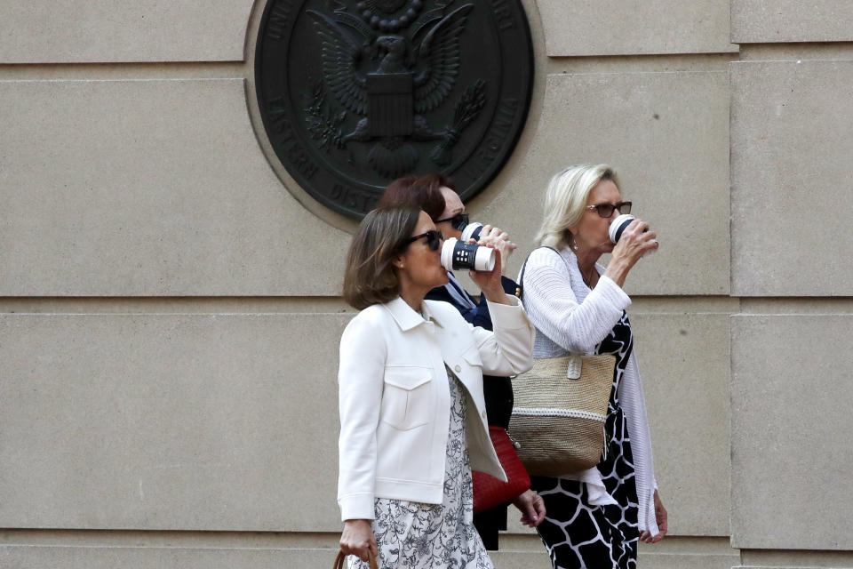 Kathleen Manafort, center, drinks from a coffee cup as she returns to federal court after a break in closing arguments in the trial of her husband, former Trump campaign chairman Paul Manafort, in Alexandria, Va., Wednesday, Aug. 15, 2018. (AP Photo/Jacquelyn Martin)