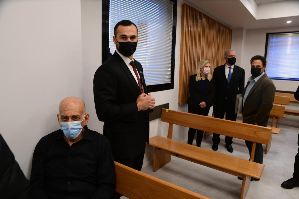 Former Israeli Prime Minister Ehud Olmert, left, and former Israeli Prime Minister Benjamin Netanyahu, second right, and his wife Sarah arrive in the Tel Aviv Magistrate's Court Monday, Jan. 10, 2022, during a preliminary hearing in a defamation lawsuit. Former Prime Minister Benjamin Netanyahu, his wife and son appeared in the Tel Aviv Magistrate’s court Monday for the opening of their case against Olmert, Netanyahu’s predecessor as Israel’s prime minister. The Netanyahus are suing Olmert for saying they suffered from “mental illness” during an interview last year. (Avshalom Sassoni/Pool Photo via AP)