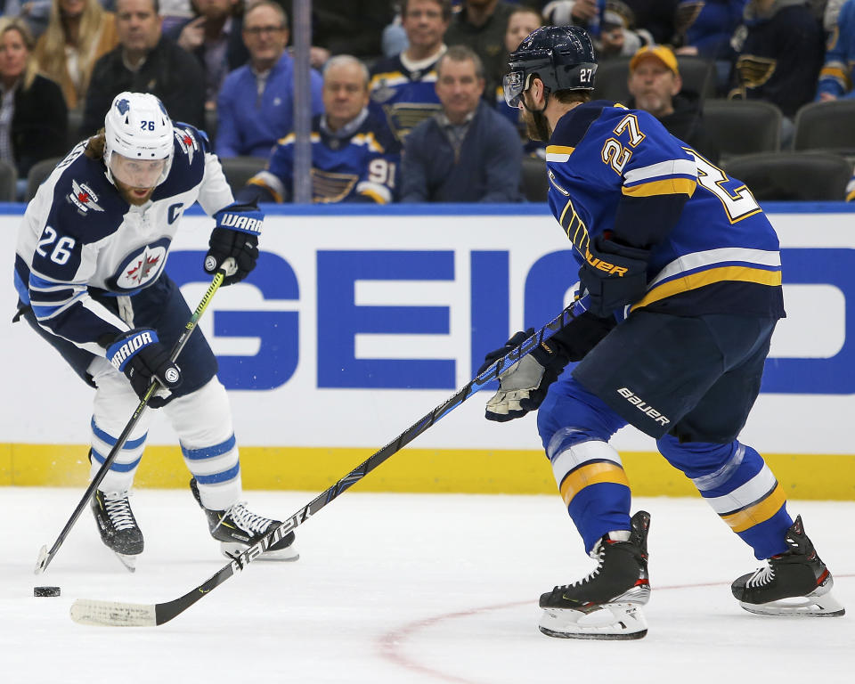 Winnipeg Jets' Blake Wheeler (26) looks to drive the puck past St. Louis Blues' Alex Pietrangelo (27) during the first period of an NHL hockey game Thursday Feb. 6, 2020, in St. Louis. (AP Photo/Scott Kane)